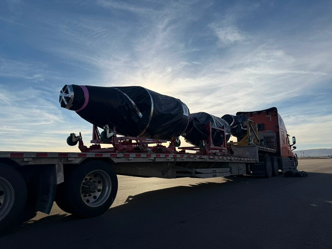 flatbed truck transporting large industrial equipment on highway